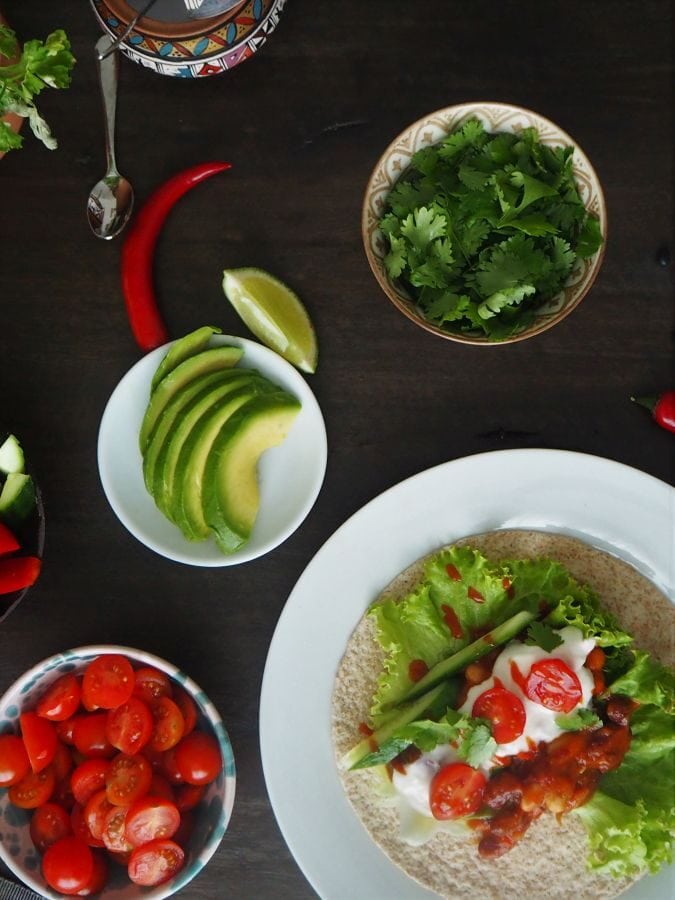 Chilli sin carne in einem Fajitas eingerappt. Vegane fajitas oder tacos. Mit Avocado, Blattsalat, Gurken, Tomaten und Korriander.